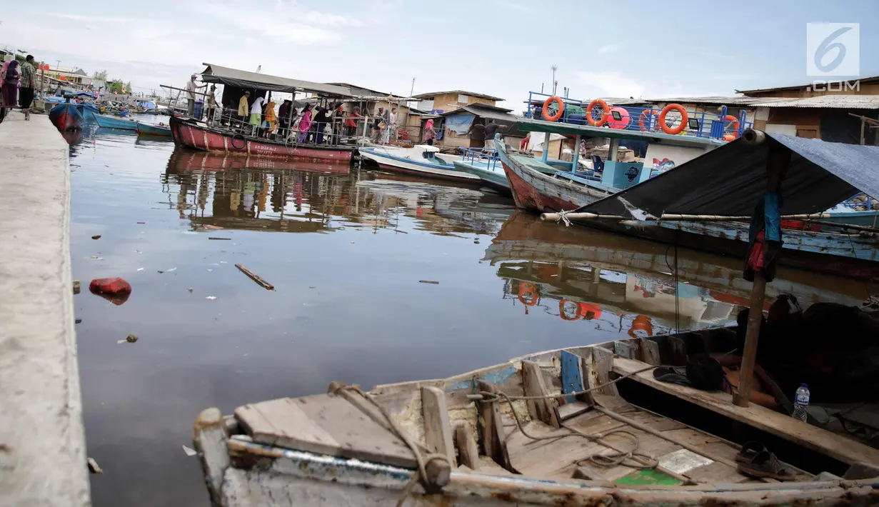 Warga menggunakan transportasi perahu eretan untuk menyebrang di kawasan kampung Akuarium, Jakarta, Minggu (12/11). Untuk menyebrang dari Luar Batang menuju kampung Akuarium atau sebaliknya penumpang dikenakan tarif semampunya.(Liputan6.com/Faizal Fanani)