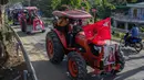 Para petani mengendarai traktor membawa poster pemimpin sipil Myanmar Aung San Suu Kyi yang ditahan saat demonstrasi menentang kudeta militer di Thongwa, di Yangon (12/2/2021).  Setelah melakukan kudeta militer Myanmar Tatmadaw telah menyatakan status darurat selama setahun. (AFP/STR)