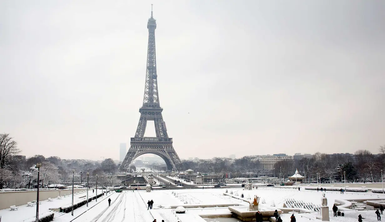 Suasana Menara Eiffel yang diselimuti salju di Paris, Prancis (7/2). Hujan salju yang sangat lebat membuat transportasi umum di paruh utara Prancis dan di Paris tidak dapat beroperasi. (AP Photo / Thibault Camus)