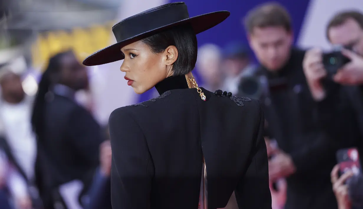 Taylor Russell berpose untuk para fotografer setibanya di pemutaran perdana film 'Bones and All' dalam Festival Film London BFI 2022 di London, Sabtu, 8 Oktober 2022. Gaunnya jatuh ke dalam rok midi terbungkus saat ia meningkatkan tinggi badannya dengan sepasang stiletto dan melengkapi penampilannya dengan topi bertepi lebar. (Photo by Scott Garfitt/Invision/AP)