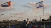 Bendera Uni Emirat Arab dan Israel dikibarkan di Jembatan Perdamaian di Netanya, Israel. (Ariel Schalit/AP)