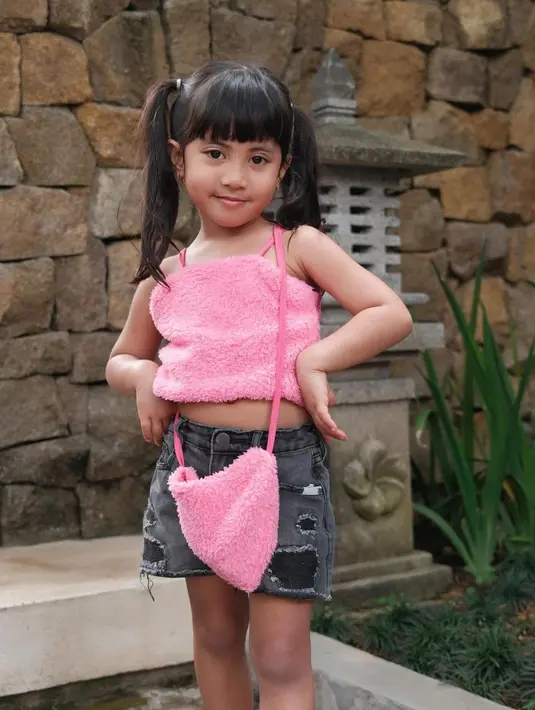 Dalam keseharian, Chava kerap tampil girly sesuai usianya. Seperti potret ini, Chava tampil manis mengenakan crop top pink, denim short pants, dan sling bag warna pink senada dengan atasannya. [@rachelvennya].