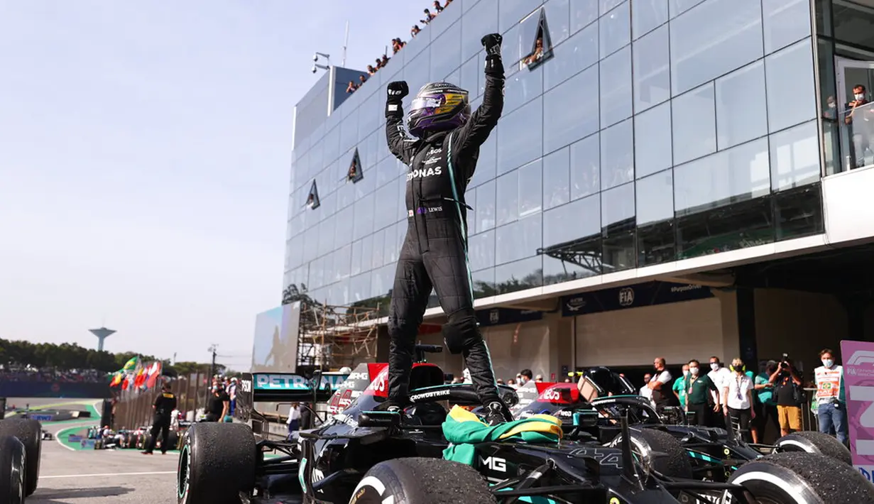 Pembalap Mercedes Lewis Hamilton merayakan kemenangannya pada Formula 1 Grand Prix di Sirkuit Interlagos, Sao Paulo, Brasil, 14 November 2021. Lewis Hamilton berada di urutan pertama, Max Verstappen kedua, dan Valtteri Bottas ketiga. (Lars Baron, Pool Photo via AP)