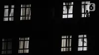 Pasien COVID-19 terlihat pada jendela salah satu kamar isolasi Rumah Sakit Darurat Wisma Atlet Kemayoran, Jakarta, Selasa (19/1/2021). Menipisnya tempat tidur isolasi dan ICU di rumah sakit rujukan COVID-19 akibat melonjaknya kasus positif pascalibur panjang. (merdeka.com/Iqbal S. Nugroho)