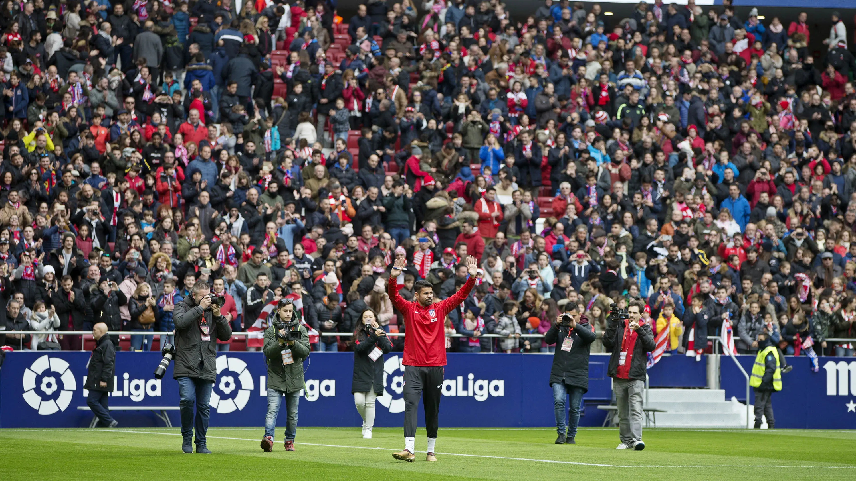 Striker Atletico Madrid, Diego Costa, menyapa suporter saat diperkenalkan di Stadion Wanda Metropolitan, Madrid, Minggu (31/12/2017). (AP/Paul White)