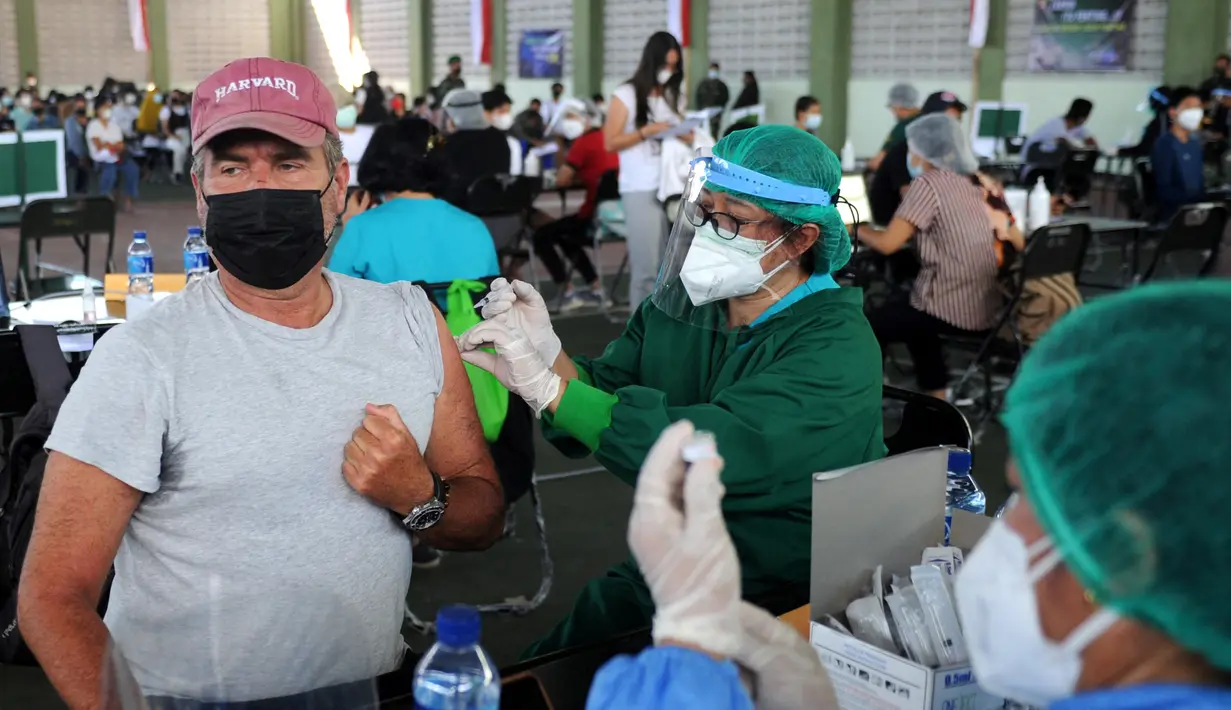 Seorang warga negara asing (WNA) menerima vaksin virus corona COVID-19 AstraZeneca di klinik vaksinasi massal darurat di Denpasar, Bali, Selasa (6/7/2021). Indonesia tengah memerangi gelombang infeksi baru yang belum pernah terjadi sebelumnya. (SONNY TUMBELAKA