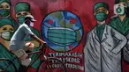 Pesepeda melintas di depan mural tentang pandemi virus COVID-19 di Jalan Raya Jakarta-Bogor, Depok, Selasa (7/4/2020). Mural tersebut ditujukan sebagai bentuk dukungan kepada tenaga medis yang menjadi garda terdepan menghadapi COVID-19 di Indonesia. (Liputan6.com/Helmi Fithriansyah)