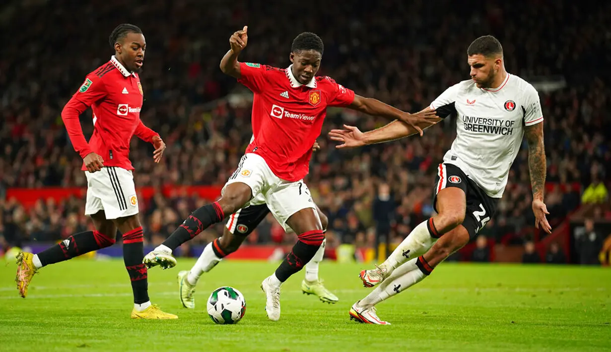Pemain Charlton Athletic Ryan Inniss (kanan) mencoba merebut bola dari pemain Manchester United Kobbie Mainoo pada pertandingan sepak bola perempat final Piala Liga Inggris atau Carabao Cup di Old Trafford, Manchester, Inggris, 10 Januari 2023. Manchester United menang 3-0. (AP Photo/Dave Thompson)