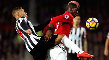 Pemain Newcastle United, Dwight Gayle berb=ebut boola dengan pemain Manchester United, Paul Pogba pada laga lanjutan Premier League pekan ke-12 di Old Trafford, Minggu (19/11). MU menang telak 4-1 atas Newcastle. (Martin Rickett/PA via AP)