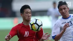 Pemain Korea Utara, Jo Sol Song (kiri) berebut bola dengan pemain Uzbekistan, Alijanov Likhomjon pada laga perdana PSSI Anniversary 2018 di Stadion Pakansari, Kab Bogor, Jumat (27/4). Laga berakhir imbang 2-2. (Liputan6.com/Helmi Fithriansyah)