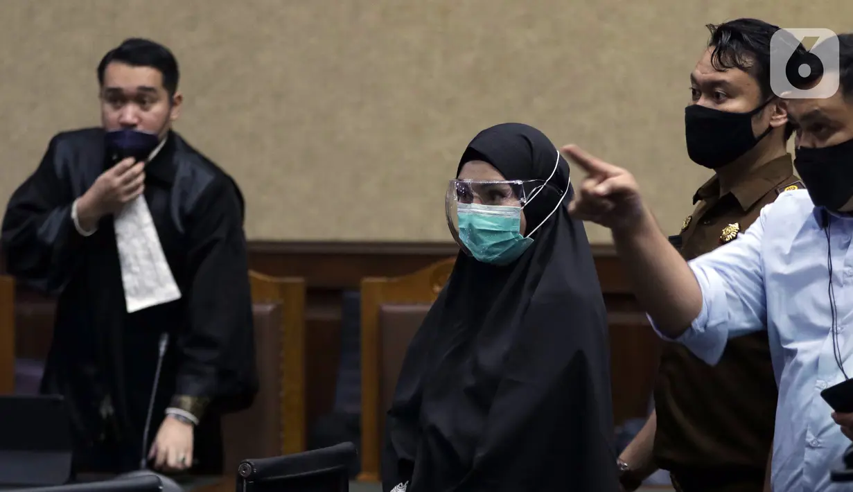 Terdakwa suap dan TPPU terkait pengurusan fatwa Mahkamah Agung untuk Djoko S Tjandra, Pinangki Sirna Malasari (tengah) saat jeda sidang pembacaan putusan di Pengadilan Tipikor Jakarta, Senin (8/2/2021). Sebelumnya, Pinangki dituntut hukuman empat tahun penjara. (Liputan6.com/Helmi Fithriansyah)
