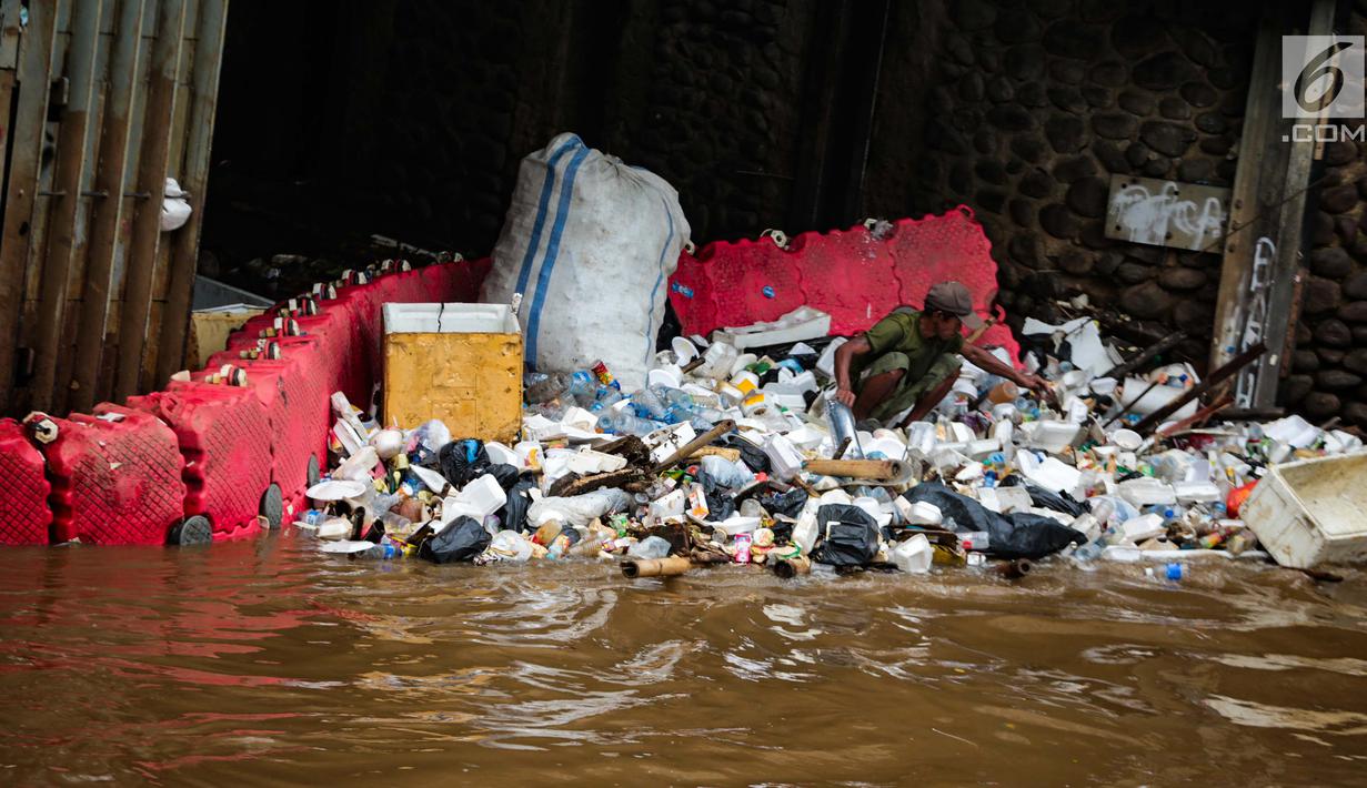 Pekerja memilah sampah saat pembersihan sampah di pintu air Manggarai, Jakarta, Selasa (4/12). Pembersihan dilakukan untuk melancarkan aliran sungai dan mencegah datangnya banjir saat memasuki musim hujan di wilayah tersebut. (Liputan6.com/Faizal Fanani)