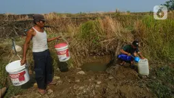 Sudah lebih dari dua bulan ratusan warga di kampung ini mengandalkan sumber air yang mirip kubangan untuk memenuhi kebutuhan sehari-hari dan air minum. (merdeka.com/Arie Basuki)