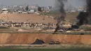 Suasana protes warga Palestina dari kibbutz Israel selatan dari Nahal Oz di perbatasan garis Gaza (6/4). Ribuan ban telah disiapkan untuk dibakar di perbatasan Gaza, tujuannya mengaburkan pandangan penembak jitu tentara Israel. (AP Photo/Tsafrir Abayov)