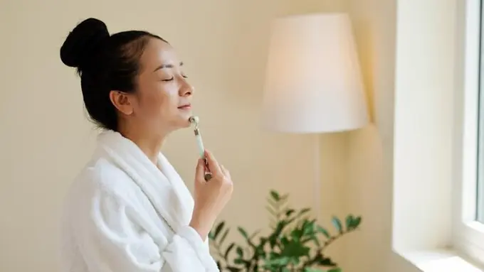 Seorang perempuan memijat wajahnya dengan menggunakan v-shape roller face (Foto Dok: Freepik/dragonimages)