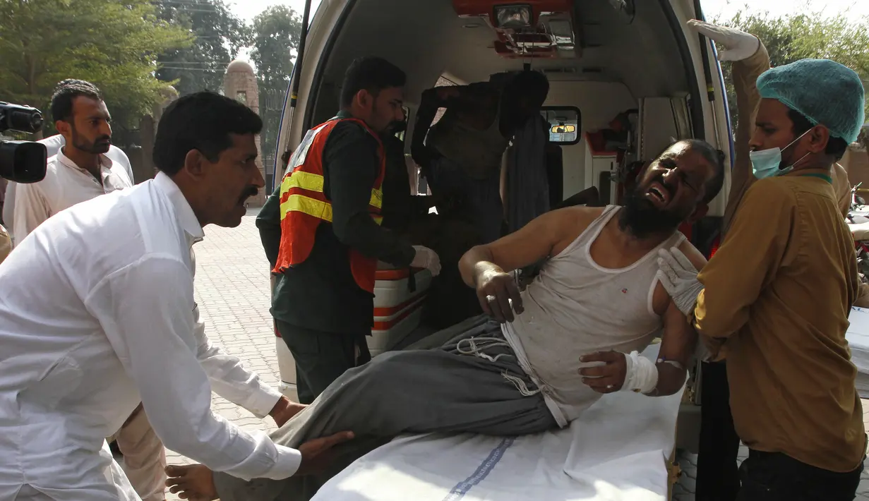Petugas rumah sakit memindahkan seorang pria yang terluka dalam kebakaran kereta api, ke sebuah rumah sakit di Multan, Pakistan  (31/10/2019). Sekitar 70 orang dilaporkan tewas dengan puluhan lainnya terluka akibat terbakarnya kereta api tersebut. (AP Photo/Asim Tanveer)