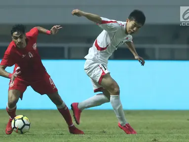 Pemain belakang Bahrain, Husain Sabba (kiri) berebut bola dengan bek Korea Utara, O Chol Hyok pada laga PSSI Anniversary Cup 2018 di Stadion Pakansari, Kab Bogor, Kamis (3/5). Laga dimenangkan Bahrain 4-1. (Liputan6.com/Helmi Fithriansyah)