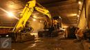 Pekerja menggunakan alat berat untuk memperbaiki jalan yang rusak berlubang di ruas Tol JORR tepatnya di terowongan Pasar Rebo, Jakarta, Senin (29/2) malam. Kondisi jalan yang rusak itu menyebabkan kemacetan panjang. (Liputan6.com/Herman Zakharia)