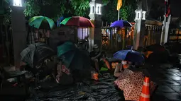 Warga tidur saat antre semalaman untuk tes swab Covid-19 gratis di Wat Phra Sri Mahathat Woramahawihan di Bangkok, Jumat (9/7/2021) dinihari. Thailand pada Kamis (8/7/2021), mencatat rekor 75 kematian Covid-19 dalam 24 jam terakhir, sehingga jumlah kematian menjadi 2.462. (Lillian SUWANRUMPHA/AFP)