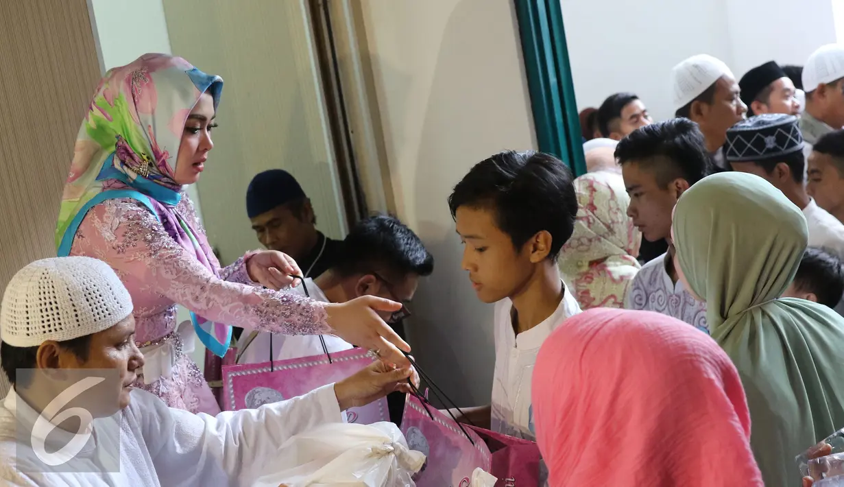 Syahrini memberi santunan kepada anak yatim saat acara Tanda Cinta Princess Syahrini di Masjid Az-Zikra, Sentul, Bogor, Jumat (24/6). Syahrini berbagi rezeki dengan 5.000 anak yatim.  (Liputan6.com/Herman Zakharia)
