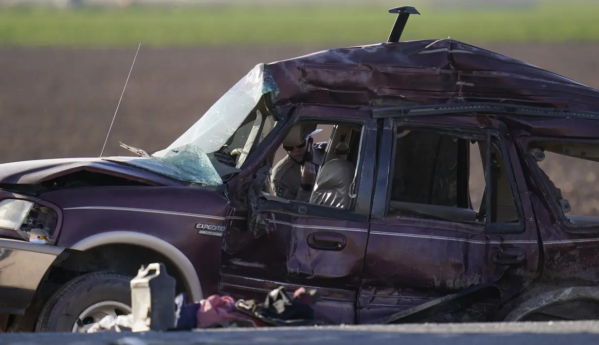 Petugas memilah bukti dan puing-puing di lokasi kecelakaan mematikan truk yang menabrak mobil SUV di Holtville, California (2/3/2021). Sopir truk gandeng itu kini dirawat karena cedera ringan. (AP Photo/Gregory Bull)