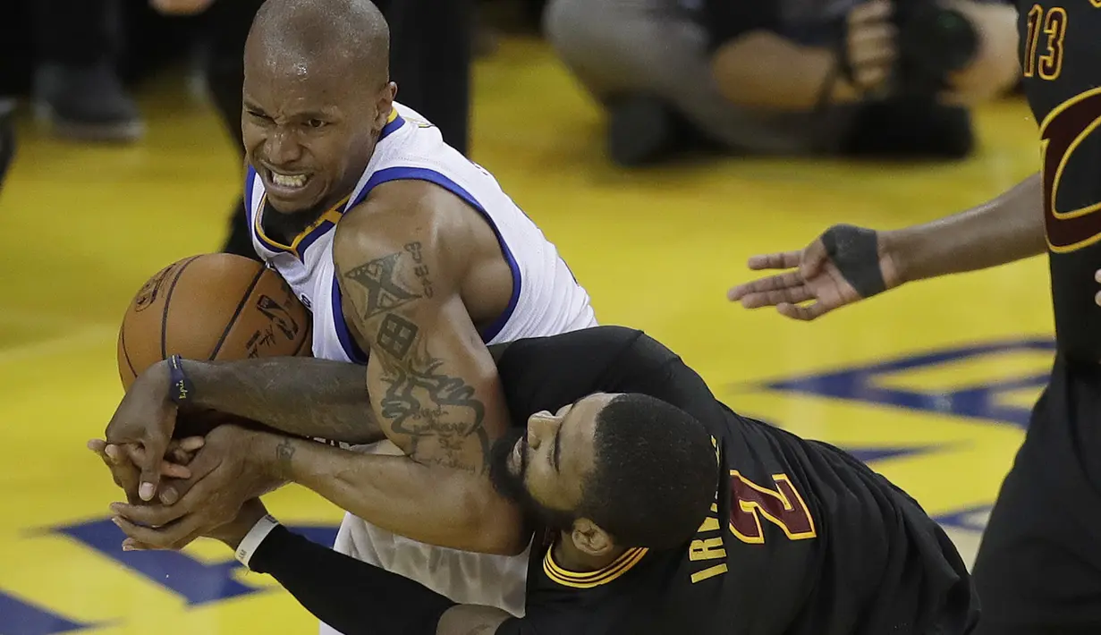 Duel pemain Warrior, David West (kiri) dan pemain Cleveland, Kyrie Irving pada laga Final NBA 2017 di  Oracle Arena, Oakland, (12/6/2017). Warriors menang 129-120. (AP/Marcio Jose Sanchez)