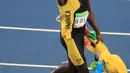 Usain Bolt membawa boneka Olimpiade Rio 2016 usai meraih emas kategori sprint 100 meter Olimpiade 2016 di Rio de Janeiro, Brasil, (15/8). Usain Bolt berhasil meraih emas di tiga Olimpiade berturut-turut. (REUTERS/Dominic Ebenbichler)