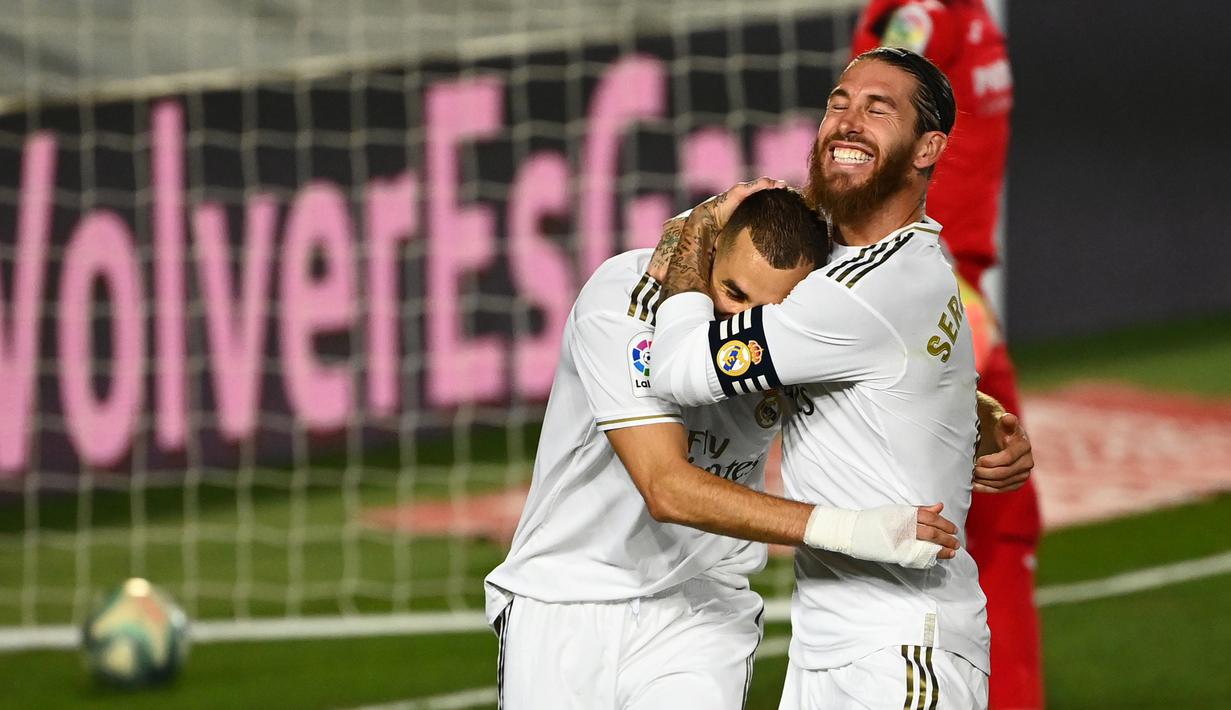 Bek Real Madrid, Sergio Ramos, merayakan gol yang dicetak Karim Benzema ke gawang Villarreal pada laga lanjutan La Liga pekan ke-37 di Estadio Alfredo Di Stefano, Jumat (17/7/2020) dini hari WIB. Real Madrid menang 2-1 atas Villarreal. (AFP/Gabriel Bouys)
