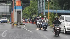 Sejumlah pengendara motor masuk menuju tol dalam kota untuk menghindari banjir, di pintu tol Taman Mini 2, Jakarta, Kamis (21/4). Hujan deras yang mengguyur sejak semalam membuat sejumlah jalan di Ibu Kota tergenang banjir. (Liputan6.com/Angga Yuniar)