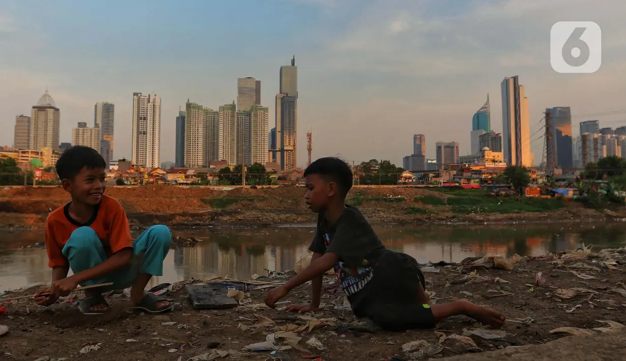 Anak anak bermain dengan latar gedung bertingkat di Jakarta, Jumat (15/12/2023). (Liputan6.com/Angga Yuniar)