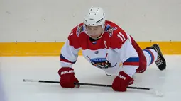 Presiden Rusia Vladimir Putin melakukan pemanasan sebelum bermain hoki es di Shayba Arena, Resor Laut Hitam Sochi, Rusia, (15/2). (Sergei Chirikov / Pool / AFP)