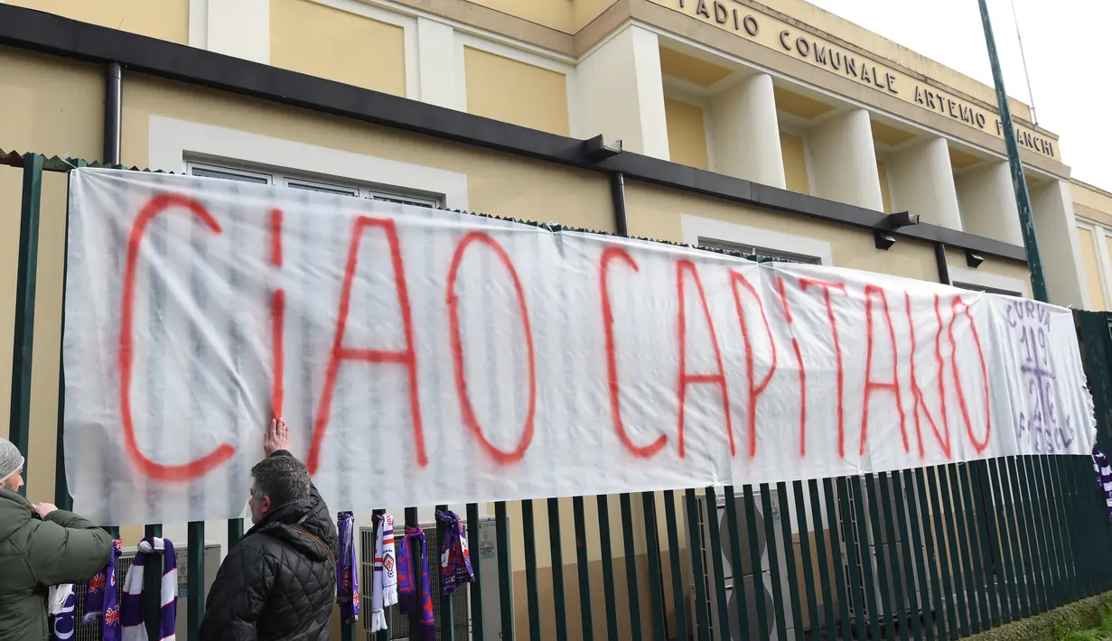 Kain putih bertuliskan 'Sampai Jumpa, Kapten' diikatkan di pagar luar Stadion Artemio Franchi di Florence, Minggu (4/3). Fans melakukan aksi belasungkawa atas kematian kapten Fiorentina Davide Astori di depan markas klub tersebut. (Claudio GIOVANNINI/AFP)