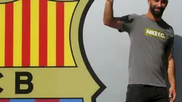 Pemain baru Barcelona, Arda Turan tersenyum menyapa awak media saat sesi perkenalan di luar Stadion Camp Nou, Barcelona, Spanyol, (9/7/2015). Arda Turan harus menunggu hingga akhir 2015 untuk dapat bermain dengan Barcelona. (REUTERS/Gustau Nacarino)