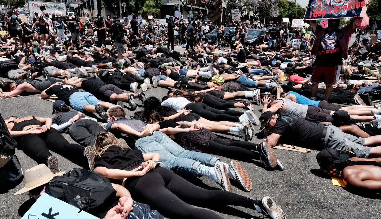 Anggota komunitas LGBTQ bersama pengunjuk rasa Black Lives Matter melakukan aksi tiarap di jalan dengan tangan seolah terikat di West Hollywood, California, Rabu (3/6/2020). Aksi menyimbolkan momen terakhir George Floyd saat lehernya ditindih lutut polisi Minneapolis pada 25 Mei. (AP/Richard Vogel)