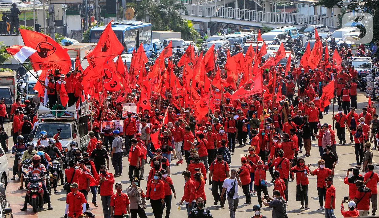 Kader PDIP Jakarta Timur melakukan aksi jalan kaki menuju Polres Jaktim, Kamis (25/6/2020). Ratusan massa simpatisan dan kader PDIP melakukan long march dengan membawa atribut partai politiknya menuntut pembakaran bendera partai pada aksi di depan DPR, Rabu 24 Juni 2020. (Liputan6.com/Johan Tallo)