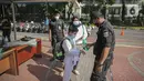 Petugas memeriksa suhu tubuh seorang anak di Lapangan Banteng, Jakarta, Sabtu (23/10/2021). Pemerintah Provinsi DKI Jakarta akan membuka 59 ruang terbuka hijau (RTH). (Liputan6.com/Faizal Fanani)