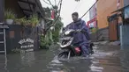 Warga melintasi genangan air di kawasan RT 10 RW 08, Kelurahan Gedong, Kecamatan Pasar Rebo, Jakarta Timur, Senin (4/8/2025). (merdeka.com/Arie Basuki)