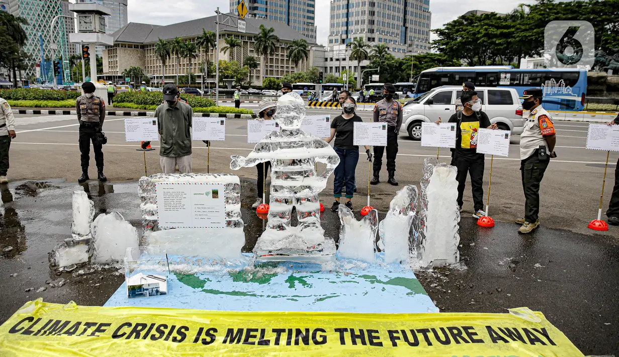 Aksi berupa patung es dalam pengantaran 1000 kartu pos oleh aktivis Greenpeace kepada Presiden Joko Widodo di kawasan Monumen Patung Kuda, Jakarta, Rabu (10/11/2021). Kartu pos itu berisikan agar pemerintah melihat dampak perubahan iklim terhadap ekosistem di sekitar. (Liputan6.com/Faizal Fanani)