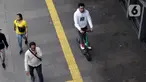 Pengguna otoped listrik Grabwheels melintas di trotoar Jalan Jenderal Sudirman, Jakarta, Kamis (14/11/2019). Pemprov DKI Jakarta melarang penggunaan otoped listrik di trotoar, Jembatan Penyeberangan Orang (JPO) serta pada pelaksanaan Hari Bebas Kendaraan. (Liputan6.com/Helmi Fithriansyah)