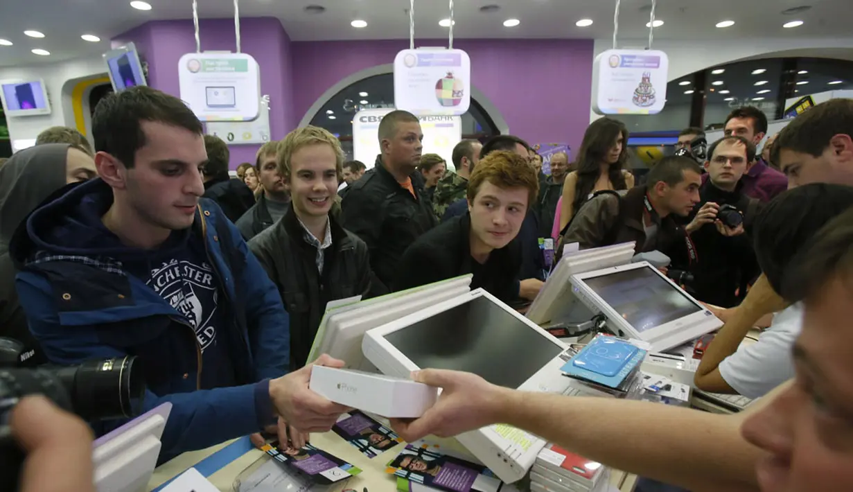 Seorang pria memegang iPhone 6 di sebuah toko ponsel di Moskow, (26/9/2014). iPhone 6 dan iPhone 6 plus mulai dipasarkan di sejumlah kota besar lain di Rusia. (REUTERS/Maxim Shemetov)