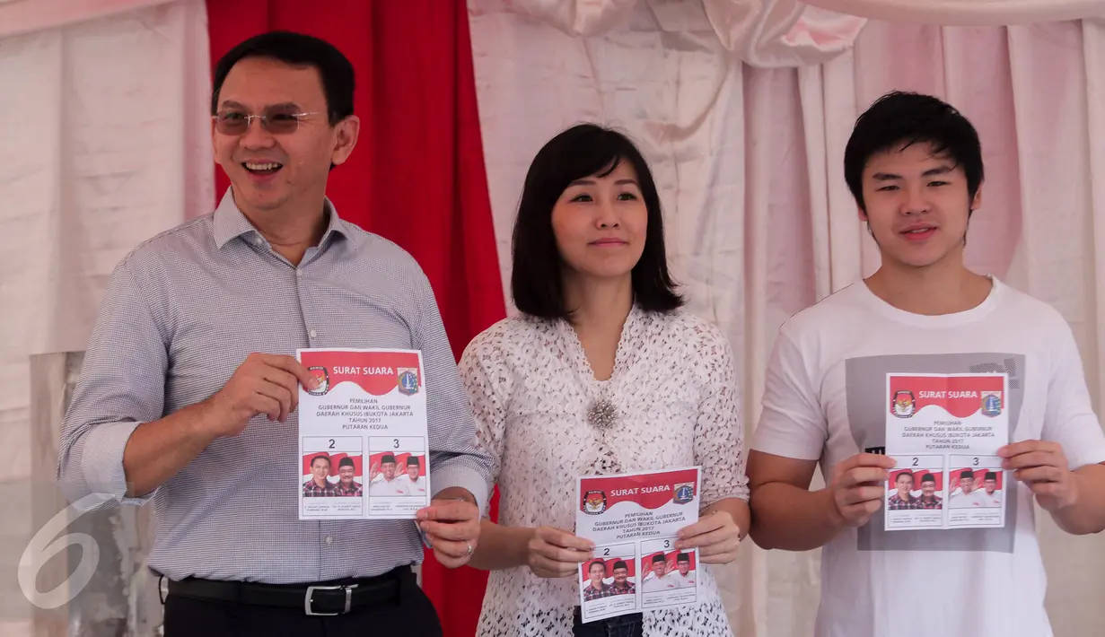 Calon gubernur DKI, Basuki Tjahaja Purnama (Ahok) bersama istri, Veronica Tan dan anaknya Nicholas Sean menunjukkan surat suara sebelum mencoblos pada Pilkada DKI putaran kedua di TPS 54 di Pluit, Jakarta Utara, Rabu (19/4). (Liputan6.com/Faizal Fanani)
