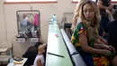 Narapidana menunggu untuk merias wajah mereka sebelum berkompetisi dalam kontes kecantikan Miss Talavera Bruce 2018 di Rio de Janeiro, Brasil, Selasa (4/12). Kontes ini digelar di penjara khusus perempuan dengan keamanan maksimum. (AP/Silvia Izquierdo)