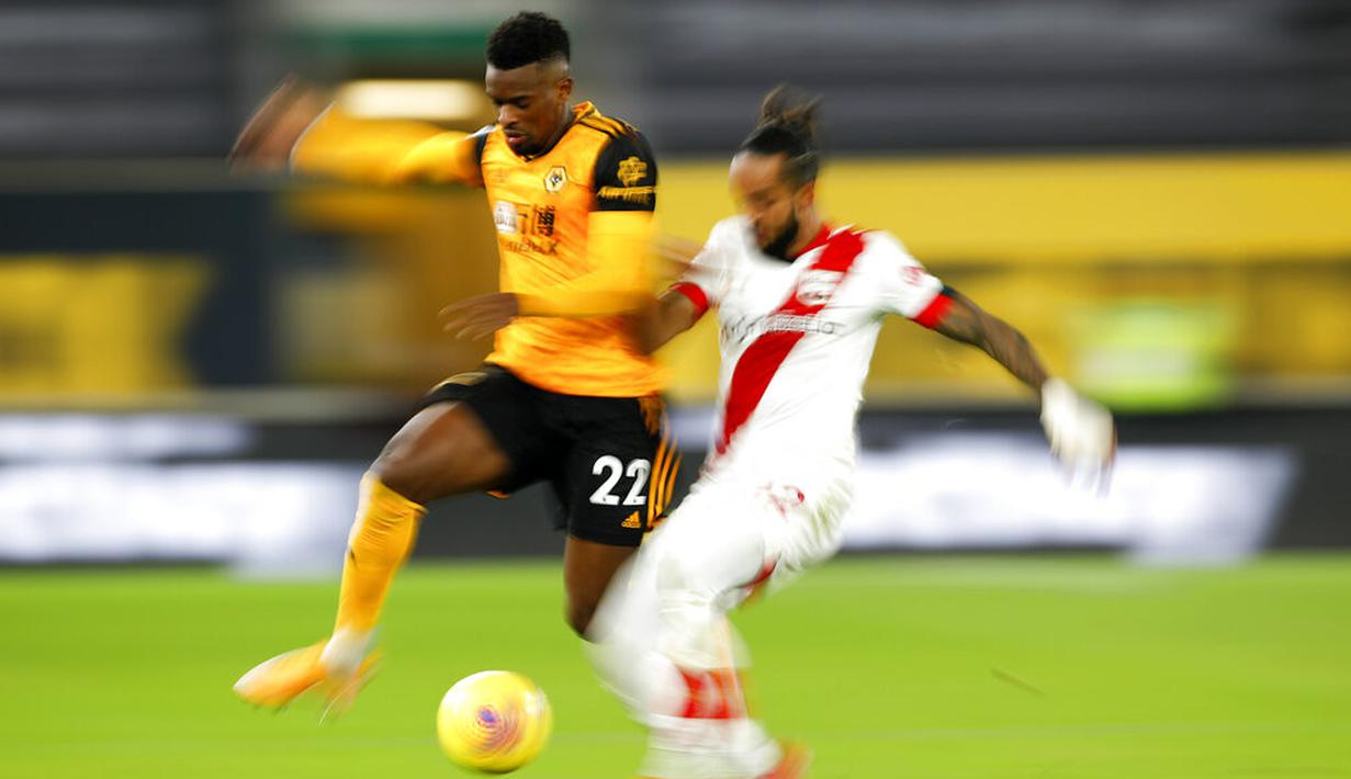 Pemain Wolverhampton Wanderers Nelson Semedo (kiri) memperebutkan bola dengan pemain Southampton Theo Walcott pada pertandingan Liga Primer Inggris di Molineux Stadium, Wolverhampton, Inggris, Senin (23/11/2020). Pertandingan berakhir 1-1. (Andrew Boyers, Pool via AP)
