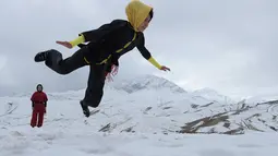 Sima Azimi menunjukkan keterampilan wushu saat latihan bersama para muridnya di puncak bukit Shahrak Haji Nabi, Kabul, 29 Januari 2017. Sima Azimi tengah melatih 20 gadis Afghanistan berusia 14-20 tahun di sebuah klub Wushu di Kabul. (WAKIL KOHSAR/AFP)