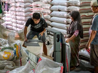 Para pekerja menyiapkan pesanan pelanggan di pasar beras utama di Jakarta pada Rabu 9 Juli 2025. (BAY ISMOYO/AFP)