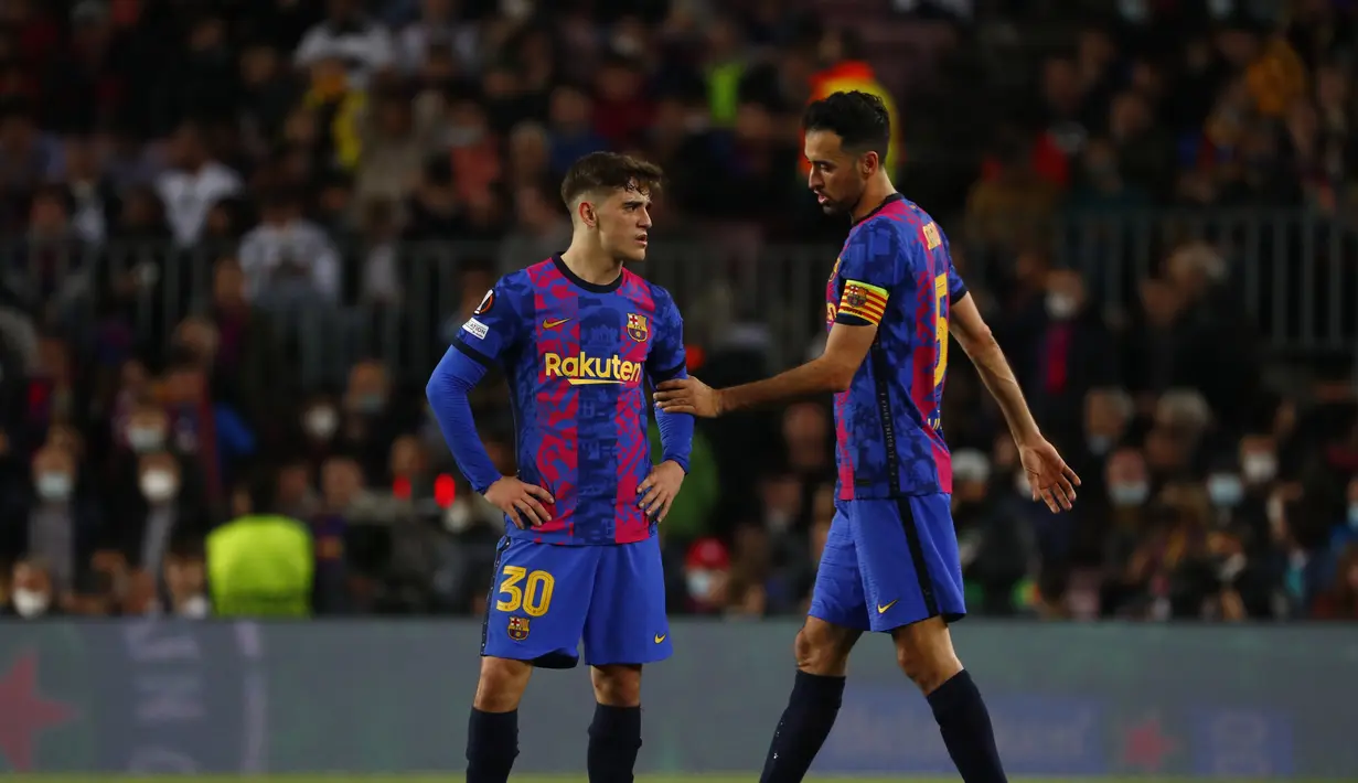Reaksi pemain Barcelona Gavi (kiri) dan Sergio Busquets ketika gelandang Eintracht Frankfurt Filip Kostic mencetak gol ketiga timnya pada leg 2 perempat final Liga Europa di Camp Nou, Jumat (15/4/2022).  Barcelona secara mengejutkan kalah 2-3 dari Eintracht Frankfurt. (AP Photo/Joan Monfort)