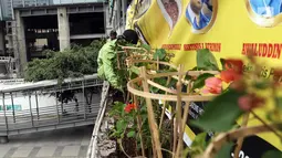 Dinas Kehutanan Provinsi DKI Jakarta menata tanaman yang dipasang di Jembatan Penyeberangan Orang (JPO) Benhil, Jakarta, Sabtu (24/8/2019). Penataan tersebut sebagai bentuk penghijauan dan mempercantik tata Kota Jakarta. (Liputan6.com/JohanTallo)
