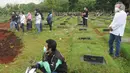 Keluarga menyaksikan pemakaman korban COVID-19 di TPU Pondok Ranggon, Cipayung, Jakarta Timur, Rabu (1/4/2020). Hari ini di TPU Pondok Ranggon hingga menjelang sore hari tercatat sembilan belas jenazah dimakamkan baik yang berstatus ODP, PDP  maupun postif  COVID-19. (merdeka.com/Arie Basuki)