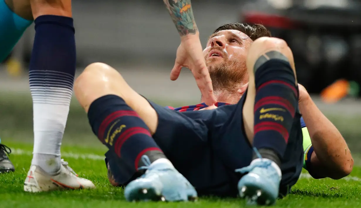 Penyerang Barcelona, Lionel Messi terjatuh di lapangan saat menghadapi Tottenham Hotspur dalam Grup B Liga Champions di Stadion Wembley, London, Rabu (3/10). Messi menyumbang dua gol saat Barcelona membantai Tottenham 4-2. (AP Photo/Frank Augstein)