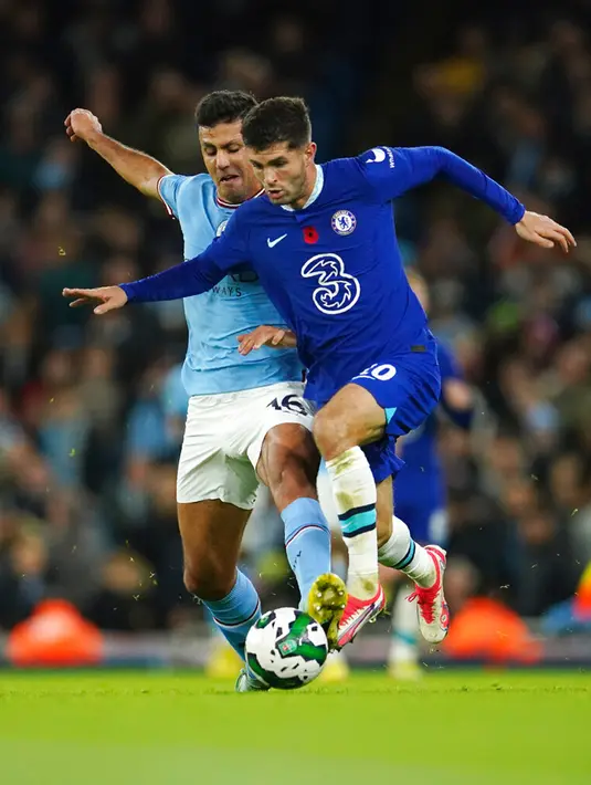 Pemain Chelsea Christian Pulisic (kanan) berebut bola dengan pemain Manchester City Rodrigo pada pertandingan sepak bola putaran ketiga Piala Liga Inggris atau Carabao Cup di Etihad Stadium, Manchester, Inggris, 9 November 2022. Manchester City menang 2-0. (AP Photo/Dave Thompson)